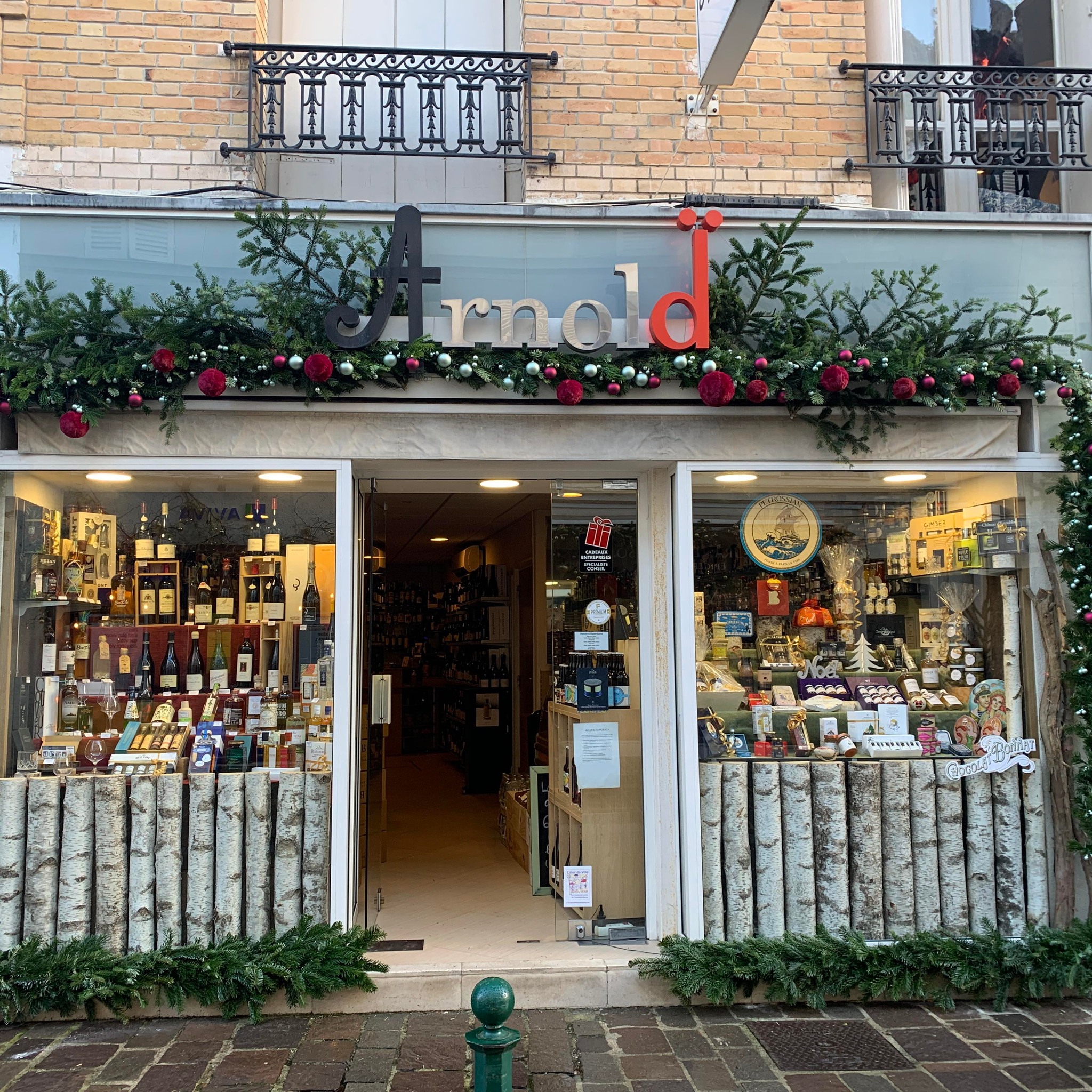 La devanture d'Arnold rue des Sablons : vitrines de grands vins et spiritueux, macaron Petrossian et coffrets cadeaux
