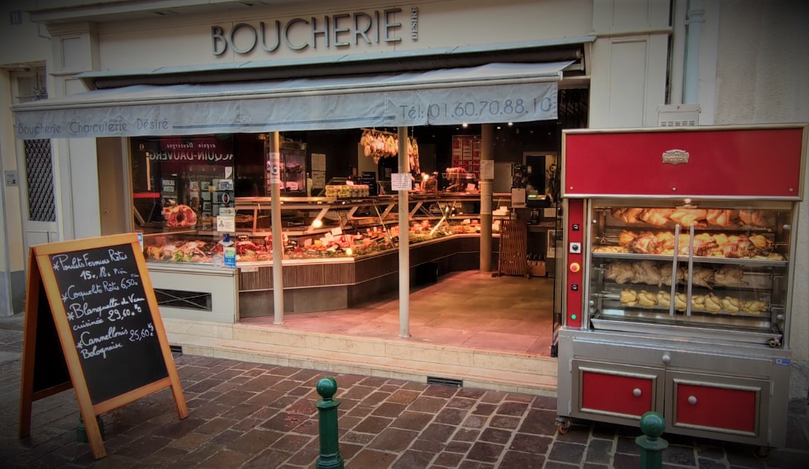 La devanture ouverte de la boucherie rue des Sablons : l'étal, la rôtissoire rouge et l'auvent historique Boucherie Charcuterie Désiré