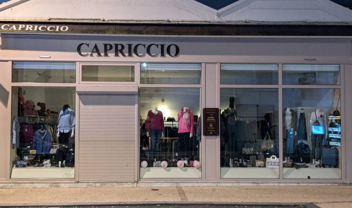 La devanture de Capriccio au Perreux, enseigne et vitrines éclairées avec mannequins en tenues