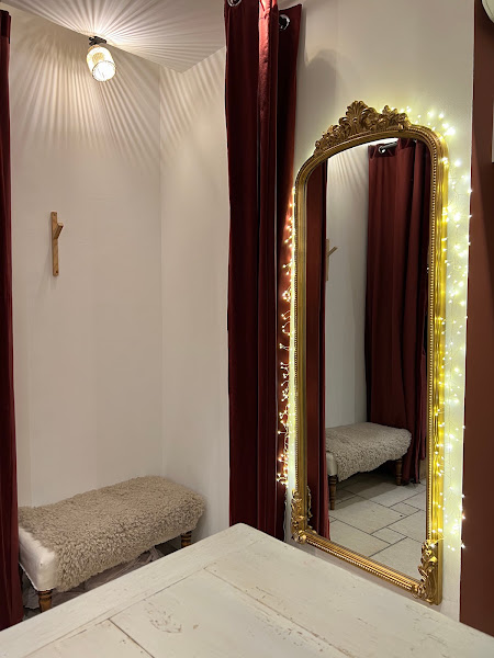 La cabine d'essayage : miroir doré baroque, guirlande lumineuse et rideau de velours