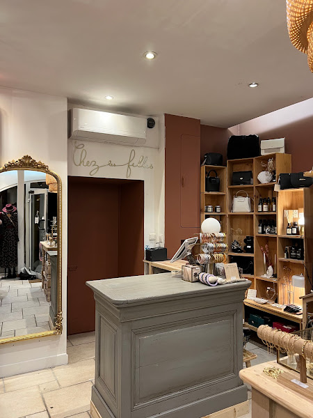 L'intérieur de la boutique : comptoir patiné, grand miroir doré, mur terracotta et présentoirs de bijoux