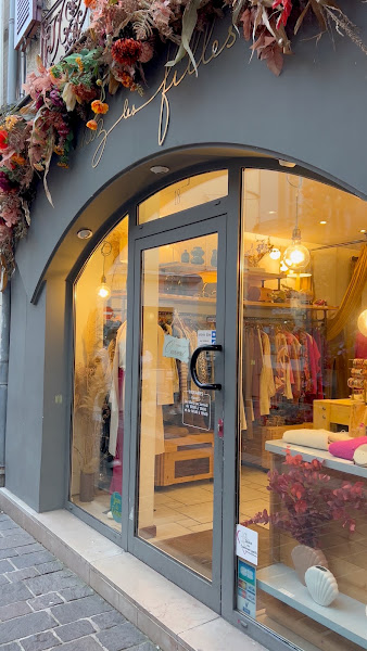 La porte vitrée cintrée de la boutique, sous les fleurs séchées de la façade