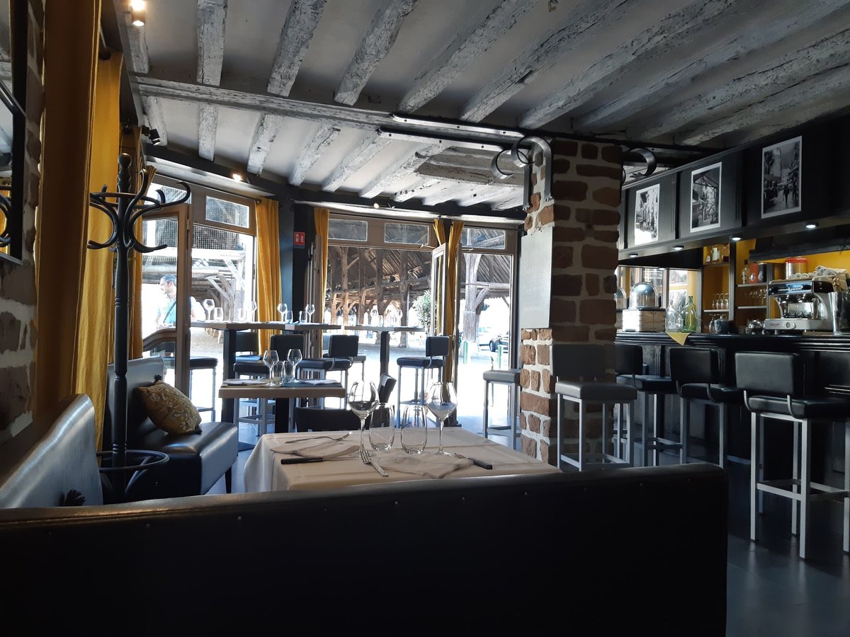 La salle chaleureuse de Colliano, poutres apparentes, tables dressées et bar